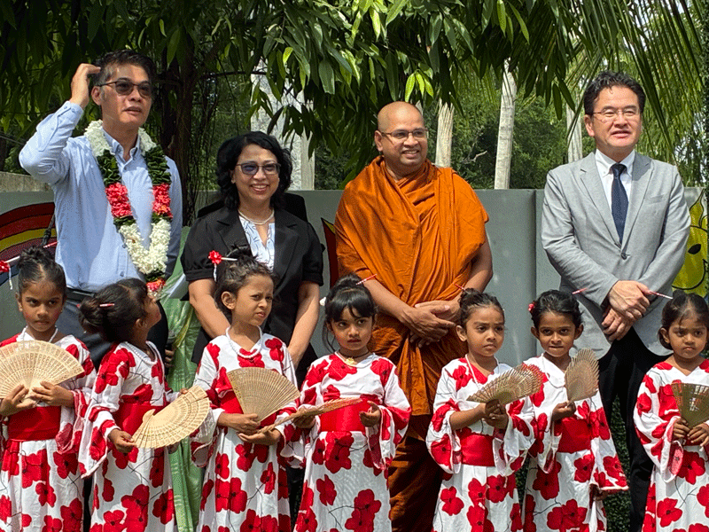 Key stakeholders stand with students at the Buddhi Preschool ceremony